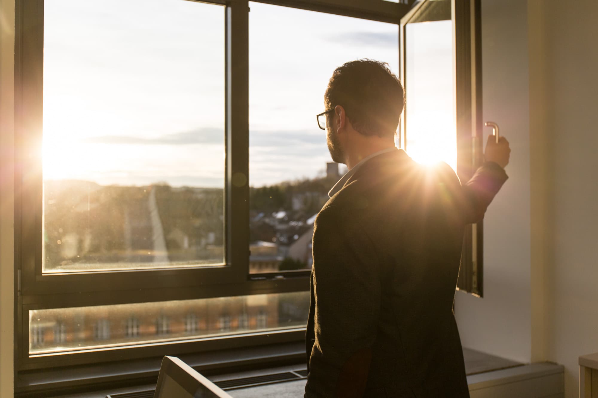 Prof. Robert Böhm blickt aus dem Fenster auf das die Abendsonne scheint