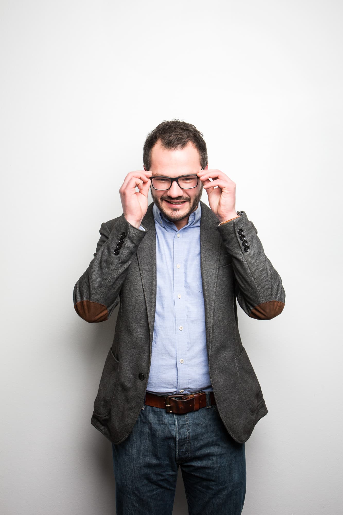 Prof. Robert Böhm richtet sich die Brille vor weißer Wand